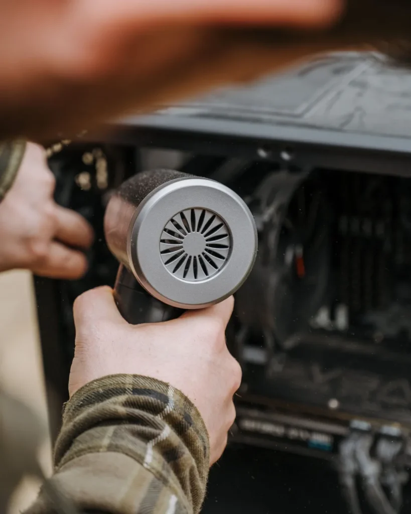 Technician cleaning dust from the inside of a desktop computer