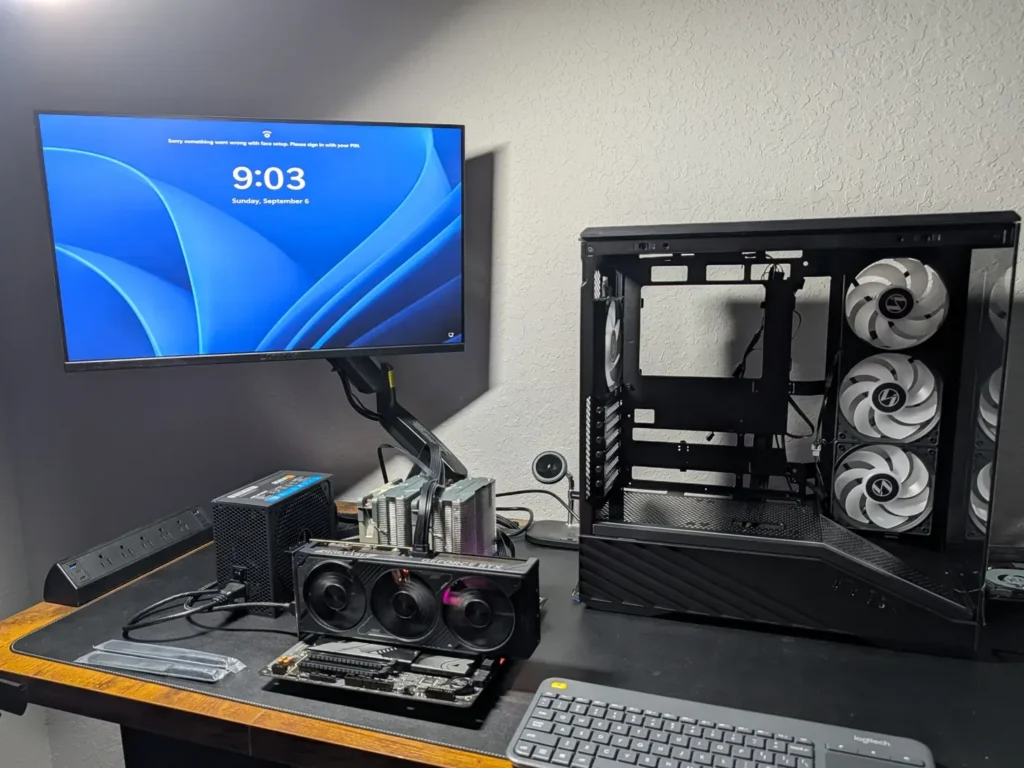 Open desktop computer case with a graphics card, power supply and motherboard on a workbench.