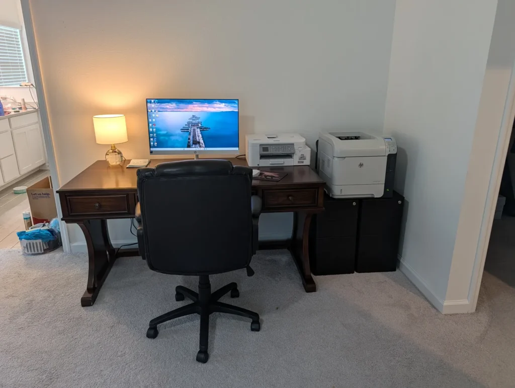 Office desk with an all-in-one computer and printers