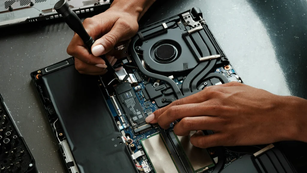 Technician repairing an open laptop during a service visit